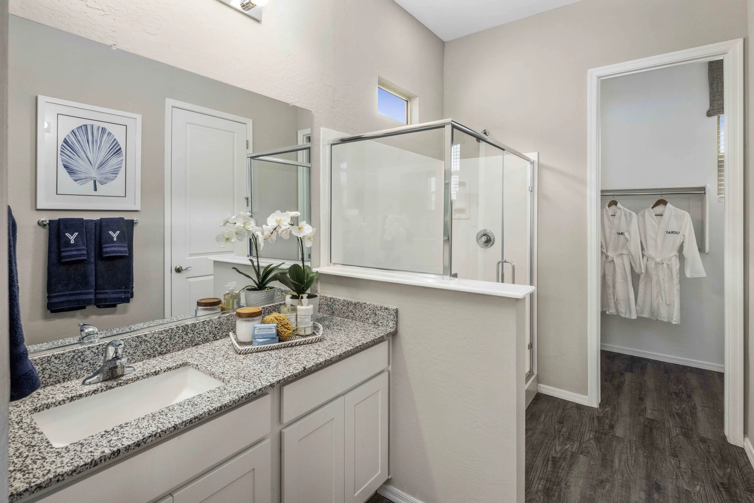 Primary bathroom with walk-in shower and walk-in closet and single vanity sink with plenty of counter space.